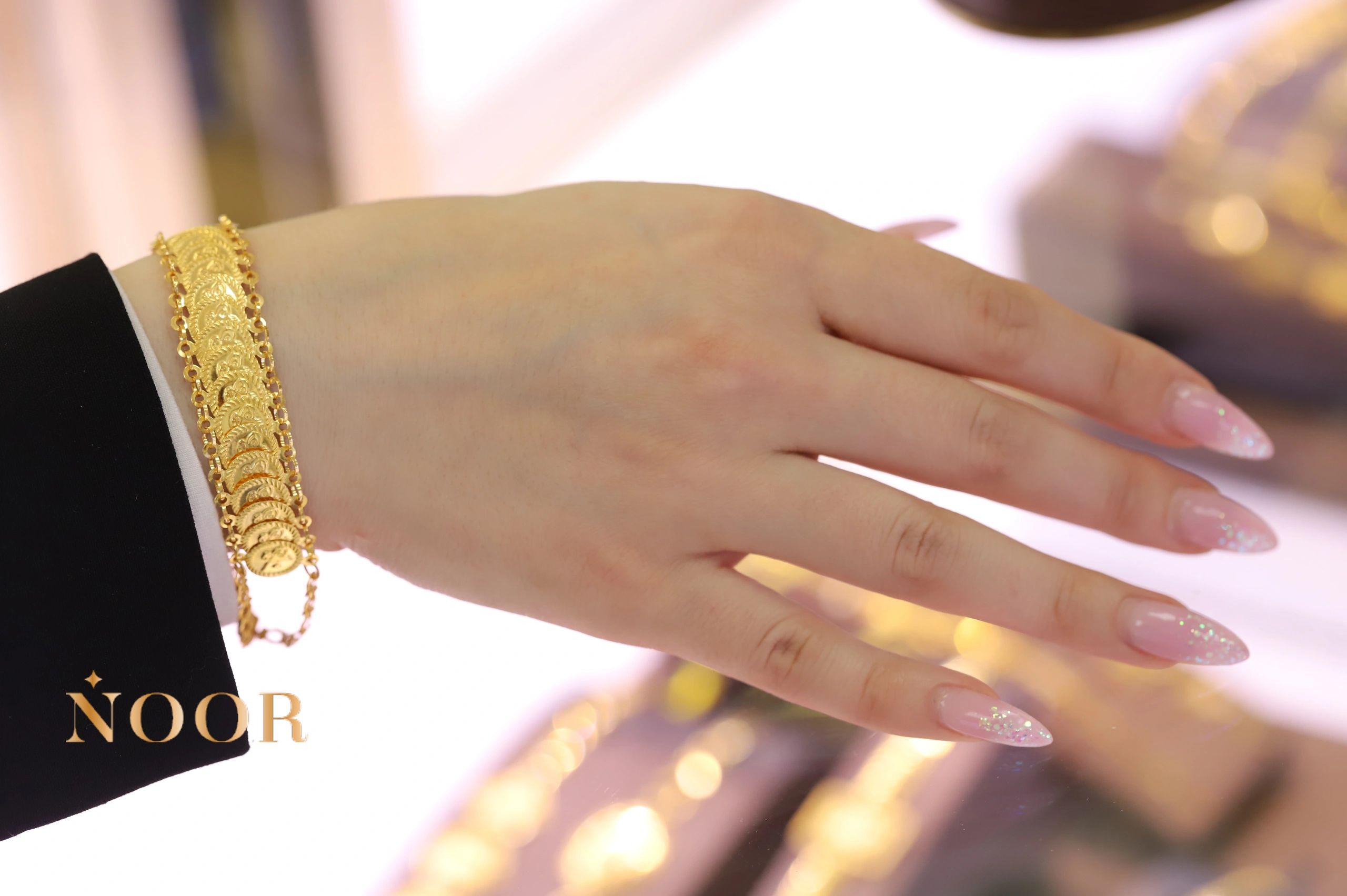 Gold liras coin bracelet on wrist